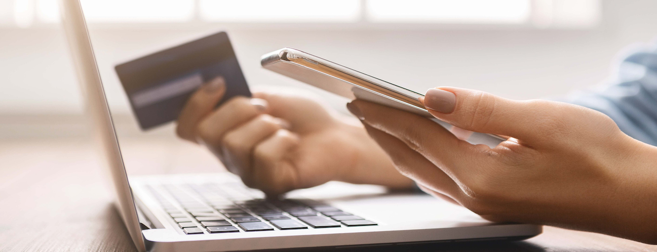 Young businesswoman booking tickets online using smartphone and credit card.