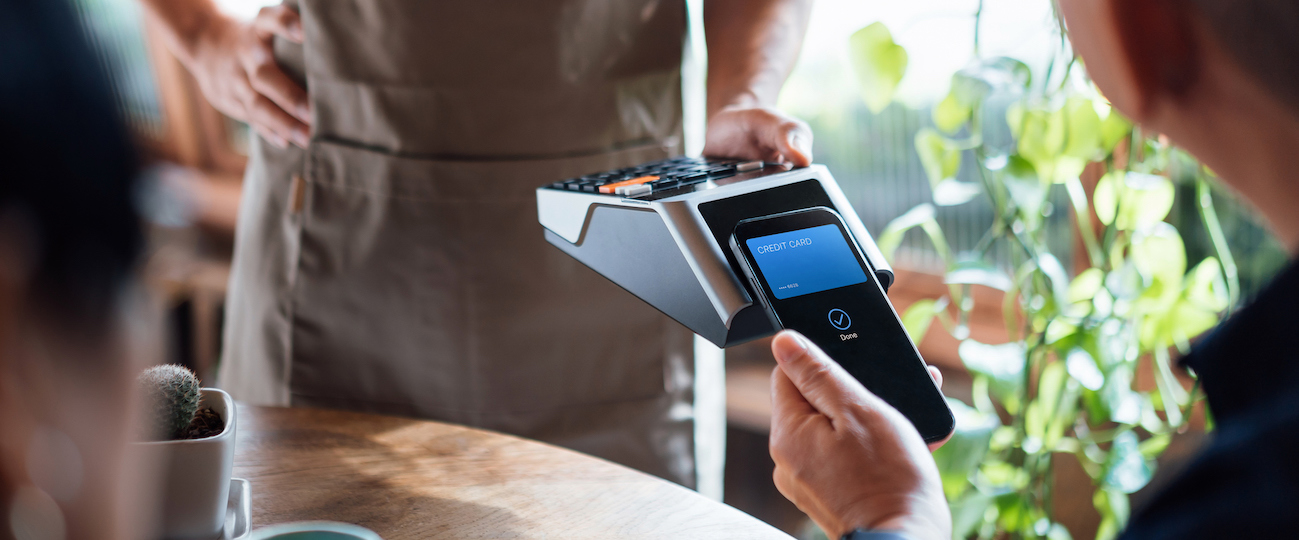 Close up of senior Asian couple paying bill with credit card contactless payment on smartphone in a restaurant, scanning on a card machine. Electronic payment. Elderly and technology